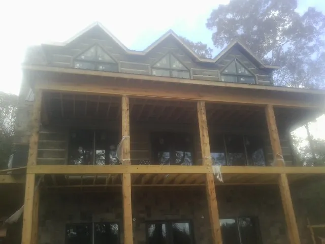 Dormers and porch framing on a large log home under construction — Roof Coating work by our crew in Punxsutawney