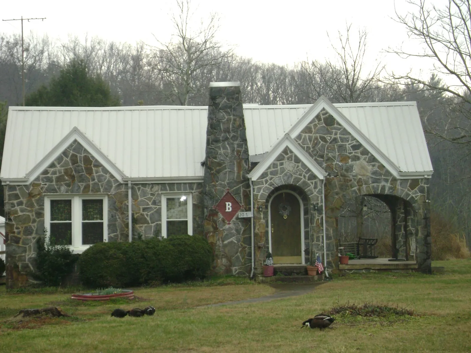 White metal roof on a stone cottage with steep gables in Punxsutawney