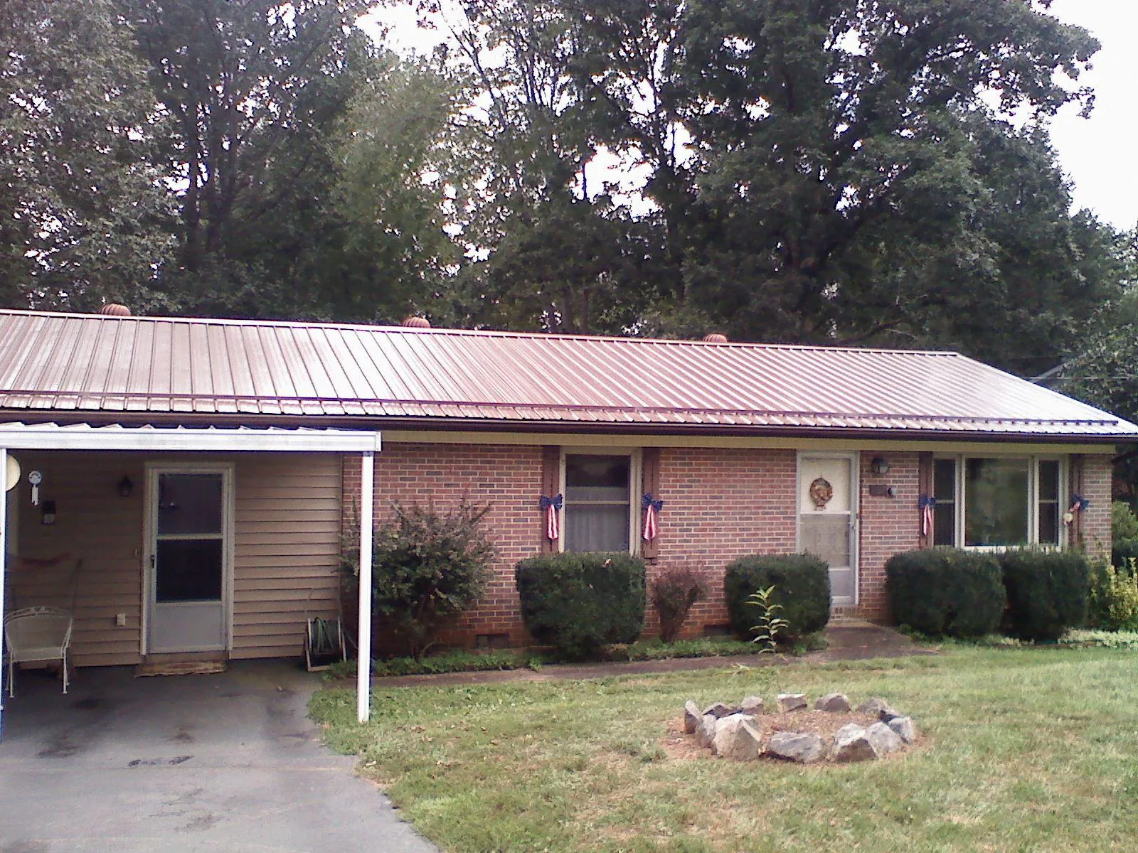 Bronze metal roof and carport on a brick ranch home — Roof Repair work by our crew in Punxsutawney